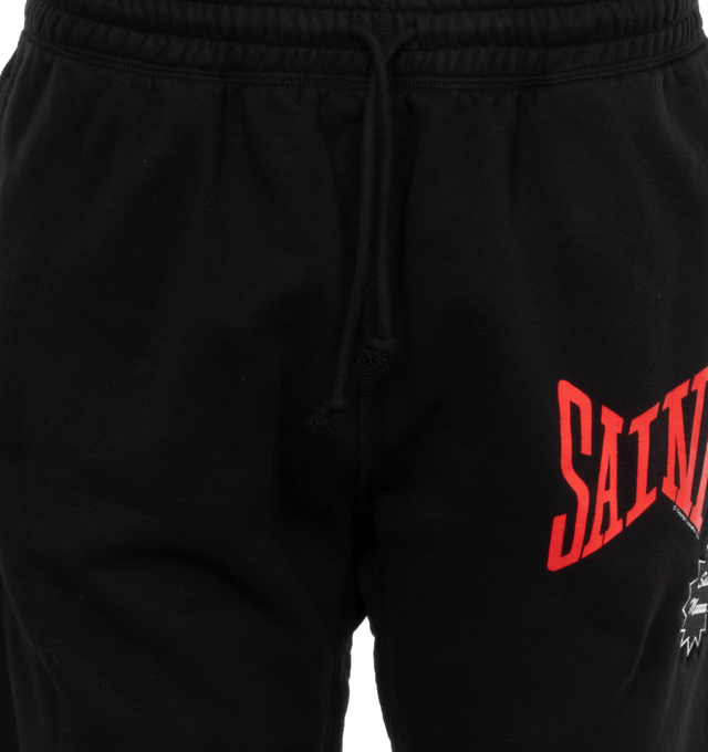 Image 4 of 4 - BLACK - SAINT MICHAEL Logo Sweatpants featuring jersey texture, elasticated waistband, two side welt pockets, logo print to the front, elasticated ankles, rear patch pocket and drawstring waist. 89% cotton, 8% polyester, 3% rayon. 