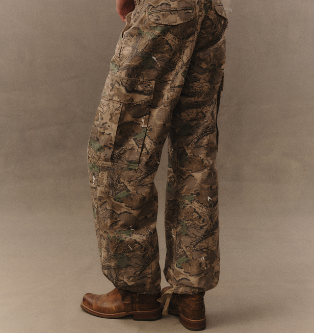 Image 6 of 7 - GREEN - Cherry LA Wide Leg Cargo Pants are crafted from custom camouflage cotton ripstop and feature a wide-leg silhouette with utility-inspired cargo pocket detailing. Designed with hidden snap closures at the pockets, paint splatter accents, and distressed finishes throughout, this statement style combines military influences with Cherry LA's signature lived-in aesthetic. Main Material: Custom Camouflage Cotton Ripstop. Fit: Wide Leg. Pockets: Cargo Pockets with Hidden Snap Closures. Detail