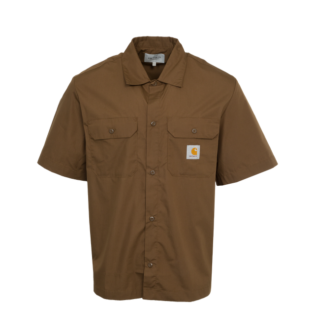 Image 1 of 3 - BROWN - CARHARTT WIP Craft Shirt featuring lightweight polycotton poplin blend, back pleat, loose fit, two chest pockets with a flap and button closure and Carhartt WIP's signature woven Square Label. 65% polyester, 35% cotton. 