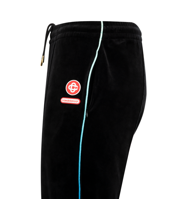 Image 3 of 3 - BLACK - CASABLANCA Velour Track Pants featuring straight-leg, elasticated waistband, drawstring fastening, pin-tuck seams down the front, piping details down the sides, in-seam side pockets, a back welt pocket with zip closure, signature interlocking CC logo and the Casablanca logo. 73% cotton, 16% polyester, 10% recycled polyester, 1% elastane. Made in Portugal.