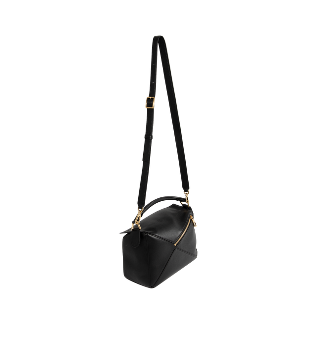 Image 2 of 3 - BLACK - Loewe Small Featherlight Puzzle bag crafted in nappa lambskin. The Puzzle is defined by its distinctive geometric lines and its cuboid form. The supple featherlight nappa makes the bag soft and slouchy. Fetauring shoulder, crossbody or hand carry, detachable and adjustable strap with rotating dogclips. Zip closure with articulated pulls, One external zipped rear pocket, one internal slip pocket, Detachable LOEWE gold or silver embossed tag with secret pocket and balloon dice, Baguette