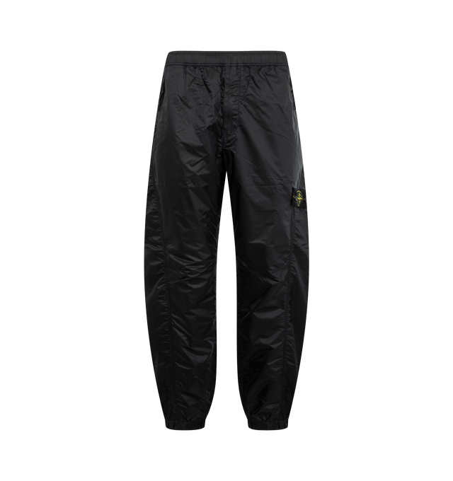 Image 1 of 3 - NAVY - STONE ISLAND Trousers featuring side zip pockets, two back pockets, Stone Island Ghost badge on left leg pocket, elasticated cuffs, elasticated waistband with internal drawstring and loose fit. 100% polyamide/nylon.