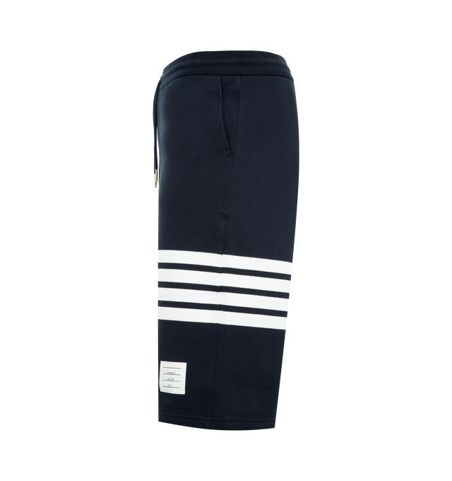 Image 3 of 3 - NAVY - THOM BROWNE Classic Loopback 4-Bar Sweatshorts featuring drawstring waistband with silver tone aglets, engineered 4-bar stripe detail at left thigh, name tag applique above left cuff, slip side pockets, single back welt pocket and signature striped grosgrain loop tab at back waist. 100% cotton. Made in Japan.