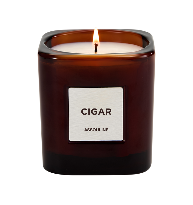 Image 2 of 3 - RED - Assouline Library Candle Cigar is a luxury scented candle that captures the warm, sophisticated ambiance of a Havana lounge with an oriental fragrance blending cedar, clove, patchouli, amber, and tonka bean. Housed in a heavyweight amber glass vessel with a textured paper label, this designer candle is crafted from a premium soy, coconut, and paraffin wax blend for a clean, even burn and exceptional scent throw. Top Notes: Allspice, Damask Rose. Heart Notes: Jasmine, Cedarwood. Base No
