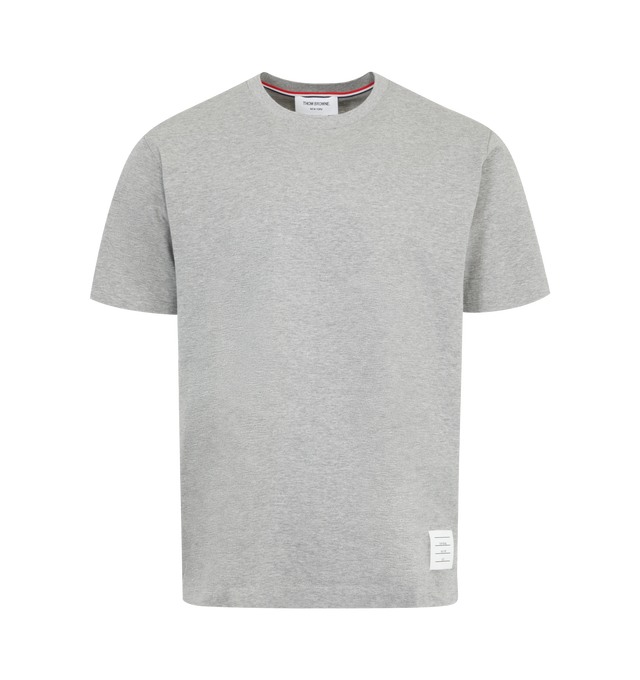 Image 1 of 2 - GREY - Thom Browne Men's Jersey Relaxed Side Slit Tee is enriched with a breathable side slit and Thom Browne emblems throughout. Featuring bound crew neckline, name tag applique above hem, shallow side slits, signature striped grosgrain loop tab at back of neck. 100% Cotton. Made in Japan.