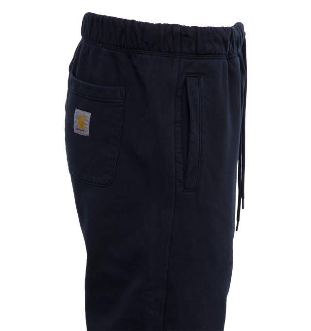 Image 3 of 5 - NAVY - CARHARTT WIP Class of 89 Sweat Pant featuring loose fit, pigment-dyed, adjustable waistband, two side pockets, one rear pocket, graphic print and square Label. 84% cotton, 16% polyester. 