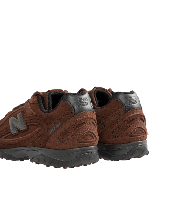 Image 3 of 5 - BROWN - New Balance 204L Sneakers feature an interpretation of 2000s running-inspired style, blending the slim proportions of vintage 1970s running shoes with modern technical detailing. Crafted with a premium suede upper, this low-profile silhouette draws inspiration from iconic New Balance designs past and present, resulting in a look that feels both familiar and contemporary. Distinctive arced overlays, screen-printed saddle graphics, and a double-stacked suede "N" logo add visual depth,