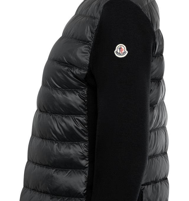 Image 3 of 3 - BLACK - MONCLER Padded Wool Zip-Up Cardigan featuring an attached drawstring hood, front zip closure, channel-quilted body, ribbed cuffs and hem, zip pockets, flap sleeve pocket, and logo patch detail. Lined body and hood. 100% polyamide/nylon. Padding: 90% down, 10% feather.