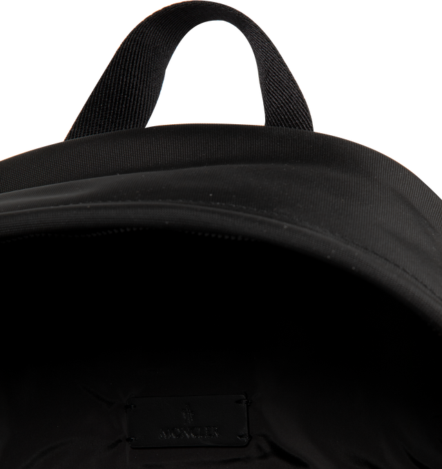 Image 3 of 3 - BLACK - MONCLER New Pierrick Water-Repellent Backpack featuring water-repellent nylon lining, leather trim, smooth leather handle, adjustable shoulder straps, two-way zipper closure, zipped pockets and metal logo. L 35 cm x H 45.5 cm x W 14 cm. 53% polyamide/nylon, 47% polyester. Lining: 100% polyamide/nylon.