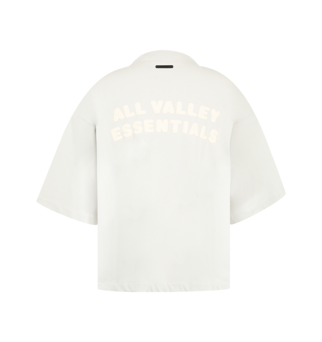 Image 2 of 2 - WHITE - The Fear Of God Men's Merch Tee is crafted from 100% cotton jersey and designed in a boxy, relaxed fit with dropped shoulders and 3/4-length sleeves. The front showcases a raised texture with a puff-printed FOG in collegiate-inspired Greek lettering, while the back displays the All Valley Essentials graphic.
