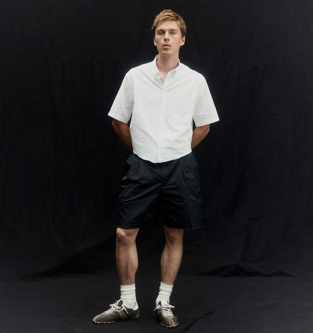 Image 2 of 5 - BLACK - MAISON MARGIELA Tailored shorts featuring exposed interior waistband, front pleats, asymmetrical belt loops and four stitches at the back. 100% polyester. Made in Italy.