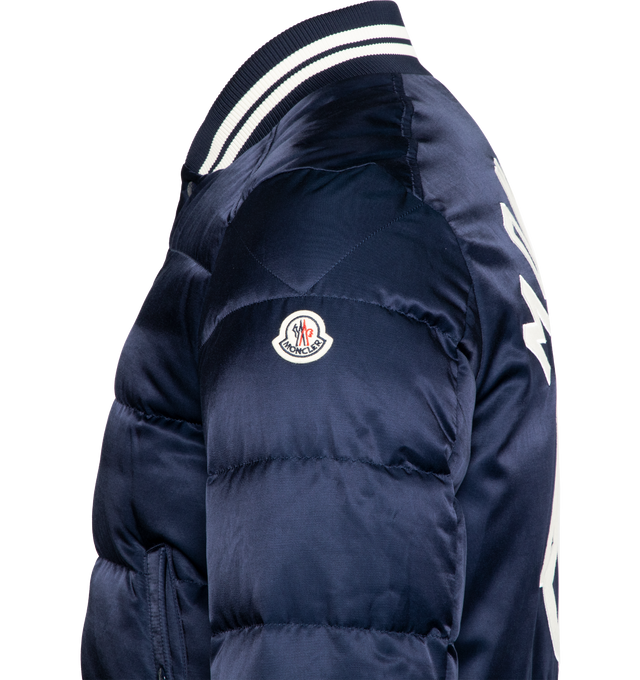 Image 3 of 3 - NAVY - MONCLER Dives Down Bomber Jacket featuring recycled longue saison lining, down-filled, embroidered logo lettering and logo, zipper and snap button closure, external pockets with snap button closure, zipped internal pocket and striped ribbed hem, collar and cuffs. Exterior: 58% cotton, 42% viscose/rayon. Lining: 100% polyamide/nylon. Padding: 90% down, 10% feather. Embroidery: 100% polyester. Ribs: 85% polyester, 13% polyamide/nylon, 2% elastane/spandex. Made in Romania. 