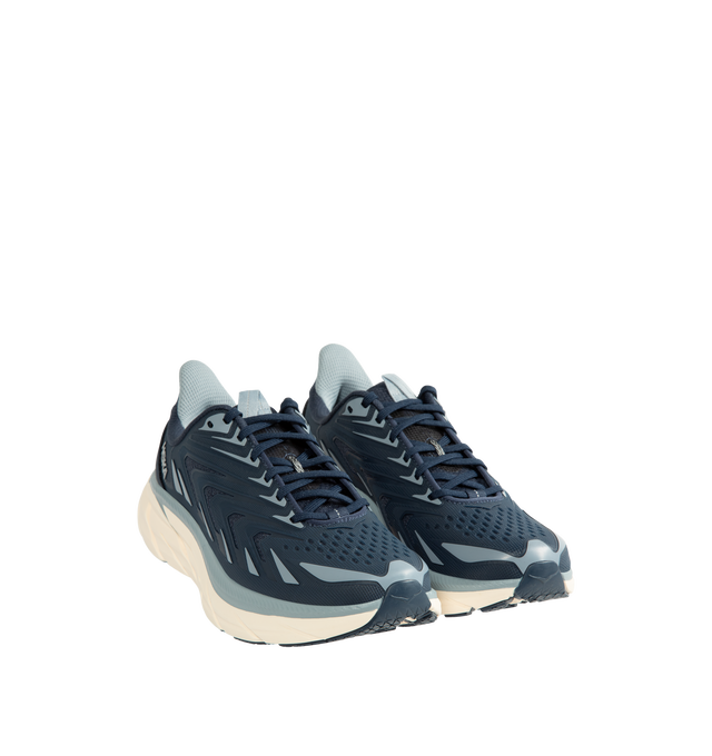 Image 2 of 5 - BLUE - Hoka Men's Clifton UTL is crafted with a breathable mesh upper and features raised PU-molded overlays that create a textured exoskeleton for added durability and support. Built on the brands popular Clifton 8 platform, this lifestyle sneaker is designed with reflective laces and webbing details, a plush CMEVA midsole, and a Durabrasion rubber outsole for everyday comfort and traction. Upper: Mesh with PU-Molded Overlays. Midsole: CMEVA. Outsole: Durabrasion Rubber. Details: Reflective