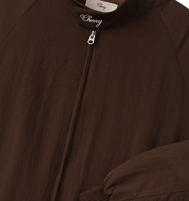 Image 3 of 7 - BROWN - Cherry LA Nylon Championship Jacket is crafted from nylon and features a regular-fit silhouette, a front nickel zip closure, and rib-knit cuffs and hem. Designed with a brushed cotton lining, welt pockets with hidden snap closures, and embroidered detailing at the neck and center back, this lightweight jacket draws inspiration from classic championship styles with a contemporary finish. Main Material: Nylon. Lining: Brushed Cotton. Made in Los Angeles, USA.