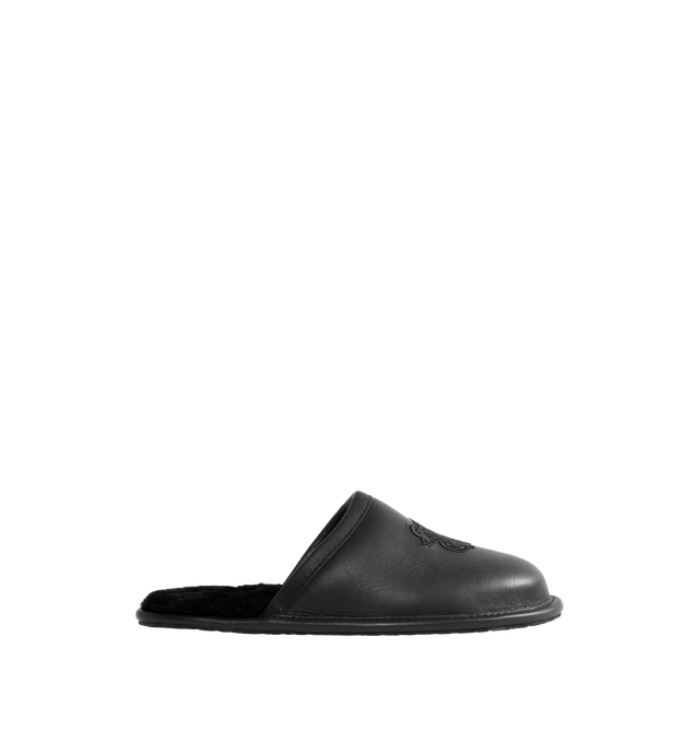 Image 1 of 4 - BLACK - UGG x Willy Chavarria Leather Hotel Slippers are crafted from black leather and feature a luxury reinterpretation of the classic hotel slipper silhouette. Designed with Chavarria's crest embroidered, and lined with UGG's signature plush sheepskin for exceptional comfort. Main Material: Leather. Lining: Sheepskin. Unisex style in men's sizes.