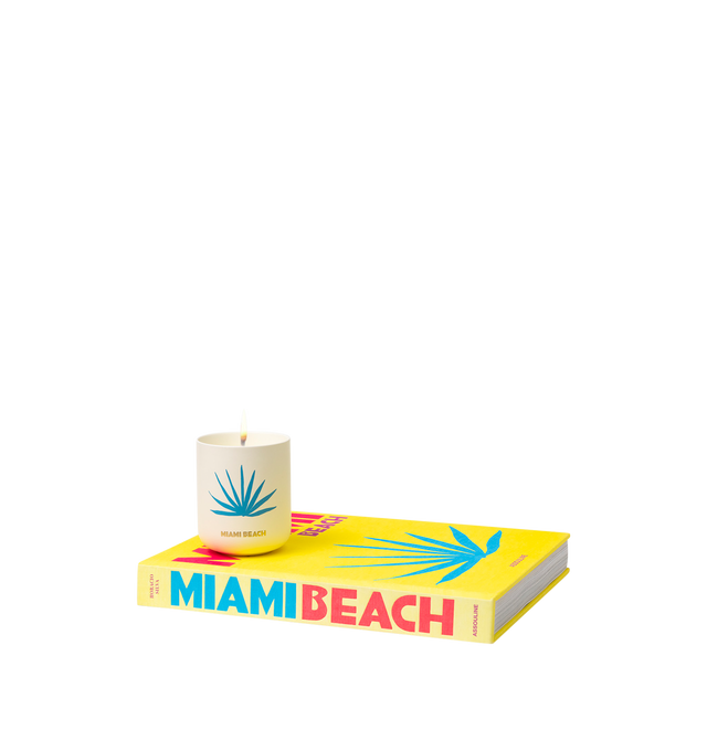 Image 4 of 5 - MULTI - Assouline Miami Beach - Travel From Home Candle. Its an everlasting summer with sun-drenched notes of bergamot, juicy peach, and smooth pistachio that capture the essence of sun-kissed beaches and lively summer beach parties. A heart of blooming florals intertwines with the balmy essence of sandalwood, creating a captivating aroma that embodies the spirited atmosphere and warmth of Miami's sultry nights. Material: Ceramic Vessel. Wax Family: Soy, Coco, Paraffin Blend. Approximate Bur