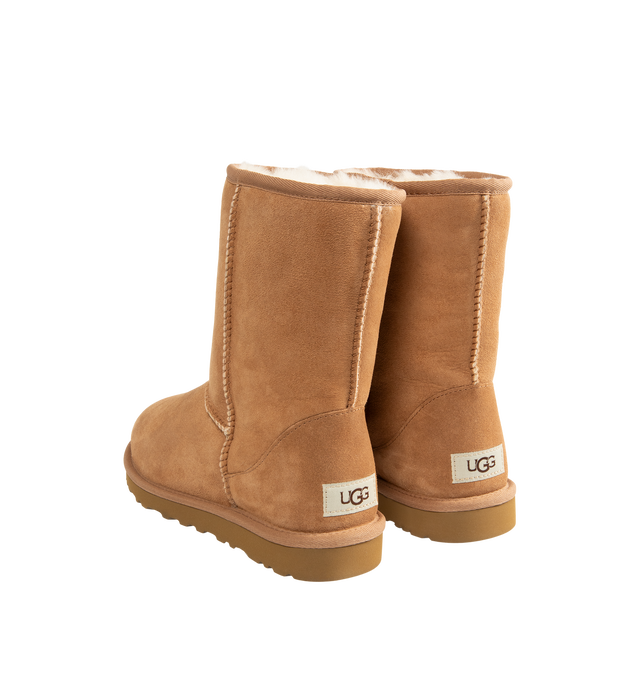 Image 3 of 4 - BROWN - UGG Men's Classic Short Boots are crafted from premium suede and feature the brand's iconic mid-calf silhouette with a soft sheepskin lining and cushioned footbed for signature warmth and comfort. These designer boots combine timeless style with lightweight cushioning and a durable outsole, making them an everyday cold-weather essential. Main Material: Suede. Lining: Sheepskin. Sole: Durable Rubber.