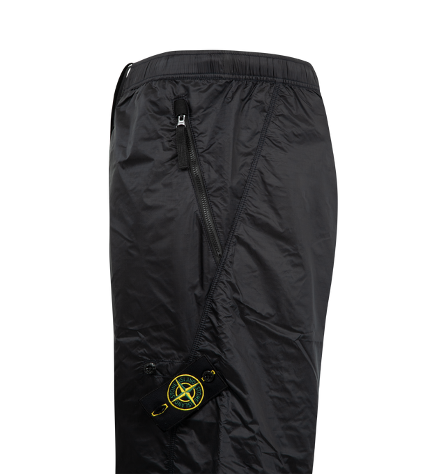 Image 3 of 3 - NAVY - STONE ISLAND Trousers featuring side zip pockets, two back pockets, Stone Island Ghost badge on left leg pocket, elasticated cuffs, elasticated waistband with internal drawstring and loose fit. 100% polyamide/nylon.