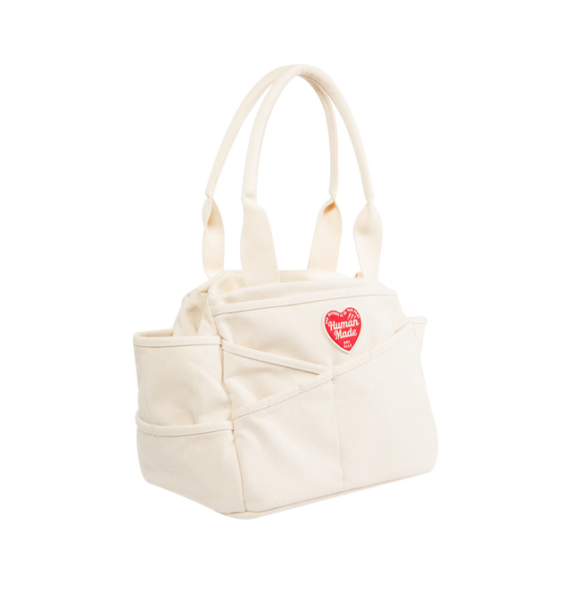 Image 2 of 3 - WHITE - HUMAN MADE Tool Bag featuring multi-pockets, made from thick, tough 18oz cotton canvas, convenient diagonal pockets below the heart patch, snap buttons for adjusting the gussets, handle also allows for shoulder carrying, graphics on both sides, Heart patch, heart name tag on the inside and A4-sized storage. 100% cotton.