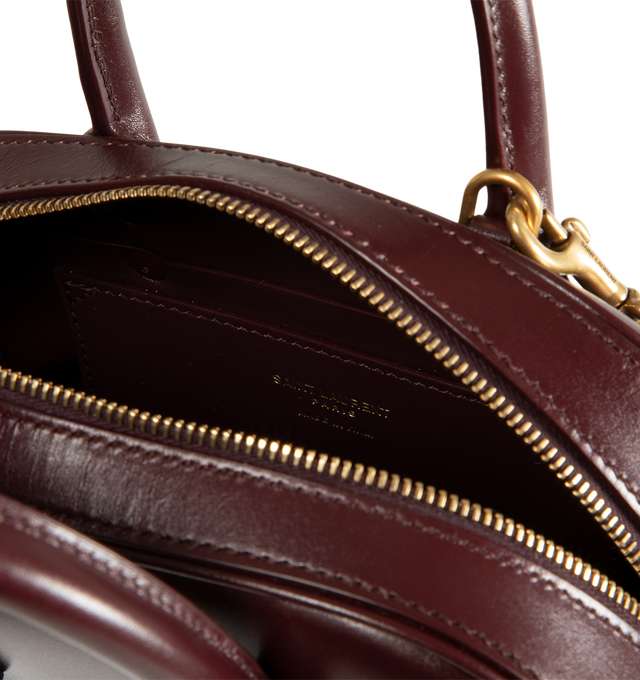 Image 3 of 3 - RED - Saint Laurent Womens Sac de Jour Mini Boston Bag is crafted from calfskin leather. Features top handles, adjustable and detachable shoulder strap, zip closure, leather lining, bronze-tone hardware, and two interior card slots. Dimensions: 19 13 7 cm; Handle Drop: 5 cm; Strap Drop: 45 cm. Main Material: Calfskin Leather; Hardware: Brass; Lining: Leather. Made in Italy.