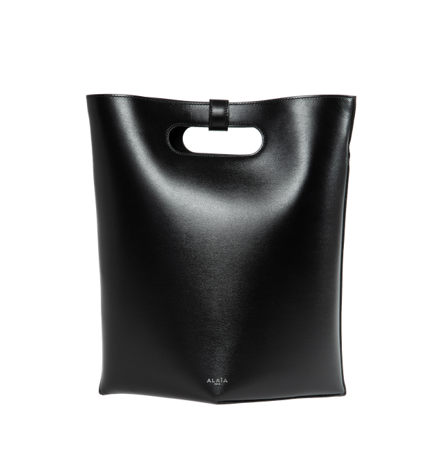 Image 1 of 3 - BLACK - ALAIA medium tote bag with unique construction folding a single piece of leather, featuring handles held together by a decorative fastener. Detachable strap style suitable for hand or shoulder carry. Dimensions (cm): l 25 x h 25 x d 14. Made in Italy. 