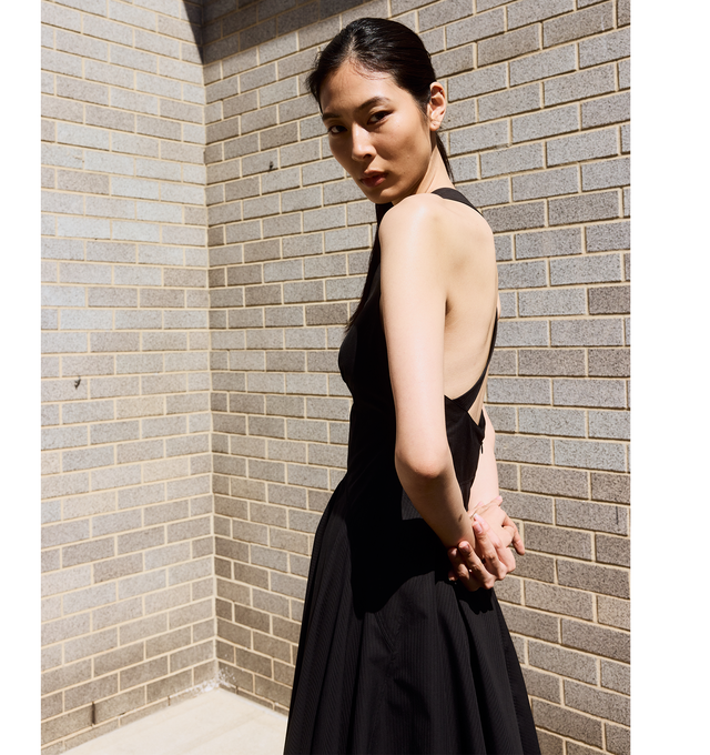 Image 4 of 4 - BLACK - Alaia V-Neck Sleeveless Crossback Cotton Midi Dress fetauring a crossover strappy low back, deep V neckline, fit-and-flare silhouette, below-the-knee length, invisible back zip. Made in Italy. 