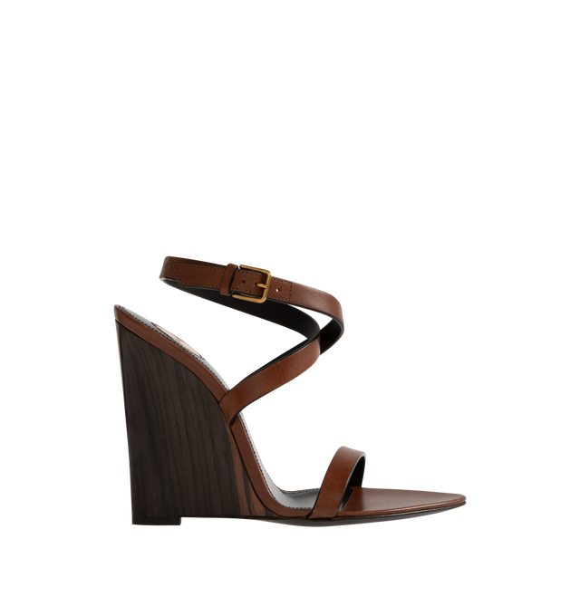 Image 1 of 4 - BROWN - SAINT LAURENT Gippy Wedge Sandal featuring ankle buckle closure, pointed toe and wedge heel. 4.3 inch wedge. Leather upper and sole. Made in Italy.