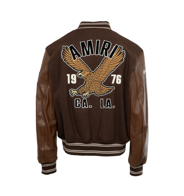 Image 2 of 4 - BROWN - AMIRI Oversized Eagle Varsity Jacket featuring front snap button closure, varsity inspired patches and side zipper pockets. 75% wool, 25% nylon. Lining: 100% viscose. Trim: 100% leather. Made in Italy. 