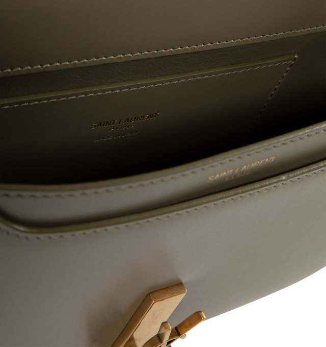 Image 3 of 3 - GREEN - SAINT LAURENT Mini Voltaire half-moon shoulder bag in calfskin with gently polished finish. Features a flap with magnetic Cassandre hinge closure and one flat interior pocket. Calfskin leather with leather lining and bronze-tone hardware. Made in Italy. Measures 8.3" X 4.3" X 1.8" with 9.4" strap drop.