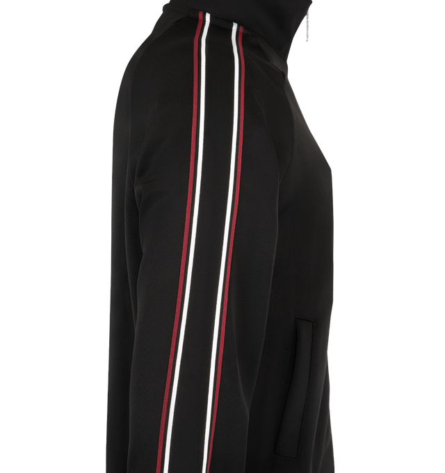 Image 3 of 3 - BLACK - Saint Laurent Mens Tracksuit Jacket is crafted from a viscose blend. Features a stand collar, front Cassandre zip closure, raglan sleeves with contrast piping, front welt pockets, and ribbed cuffs and hem. Main Material: Viscose, Polyamide, Elastane. Made in Italy.