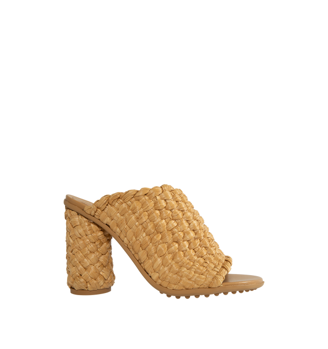 Image 1 of 4 - BROWN - BOTTEGA VENETA Atomic Intrecciato Raffia Sandals featuring woven raffia into a towering silhouette set atop a thick cylindrical heel, rubber-gripped soles and slips on. 4" heel. Raffia. Made in Italy. 