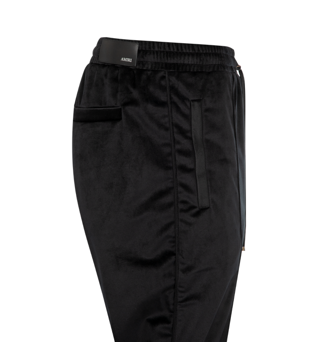 Image 3 of 3 - BLACK - AMIRI Velvet Flare Track Pant featuring back welt pockets, side slit pockets, elastic waist with drawstring, logo patch on back and flared leg. Made in Italy.