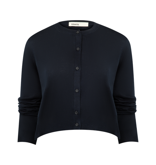Image 1 of 3 - NAVY - KHAITE Nadyne Cardigan featuring a finely knit cardigan, compact, jersey-stitched silhouette, side slits, button front closure and 1x1 ribbing at the crewneck, bracelet-length sleeves, and hem. 95% silk, 4% polyamide, 1% polyurethane.