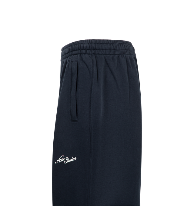 Image 3 of 3 - BLUE - Acne Studios Fleece Logo Sweatpants are crafted from brushed organic cotton fleece and feature a loose unisex silhouette with a mid-rise waist and long, baggy legs. Designed with an elasticated waistband and adjustable drawcord, these designer sweatpants are finished with side zip pockets and an embroidered seasonal logo for a signature finish. Main Material: 100% Cotton. Fit: Loose Unisex Fit. Rise: Mid-Waist. Details: Long Baggy Legs, Elastic Waistband with Drawcord, Side Zip Pockets