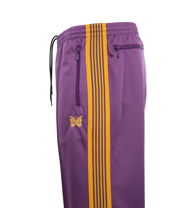 Image 3 of 3 - PURPLE - NEEDLES Track Pants featuring polyester interlock jersey, concealed drawstring at elasticized waistband, three-pocket styling, pinched seams and embroidered logo graphic at front and striped knit trim at outseams. 100% polyester. Made in Japan.