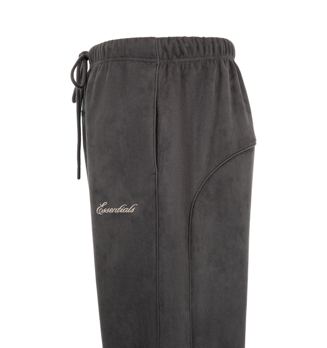 Image 3 of 3 - BLACK - Fear of God ESSENTIALS Men's Signature Relaxed Sweatpant with Piping is crafted from bonded suede fleece and features a relaxed straight-leg silhouette designed for elevated comfort and everyday wear. Accented with sportswear-inspired piping and an embroidered Essentials signature logo at the leg, this premium style is finished with side pockets, adjustable ankle bungees with toggles, an encased elastic waistband with drawstrings, and a signature Essentials label at the center front.