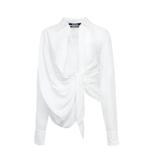 Image 1 of 2 - WHITE - JACQUEMUS La Chemise Bahia Shirt featuring twisted, straight fit, pointed collar, plunging, draped neckline, hidden button under the sewn knot, square cuffs with mother-of-pearl buttons and asymmetric hem. 88% viscose, 12% polyamide/nylon. Made in Portugal. 