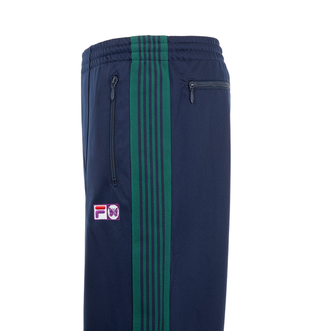 Image 3 of 3 - BLUE - Needles x Fila Men's Ventisei Track Pant is crafted from polyester and features a relaxed track pant silhouette inspired by FILA's sportswear heritage. Designed as part of the first collaboration between Needles and FILA, it is finished with bold color-block detailing, signature branding accents, and an elasticized waistband for everyday comfort. Main Material: 100% Polyester.