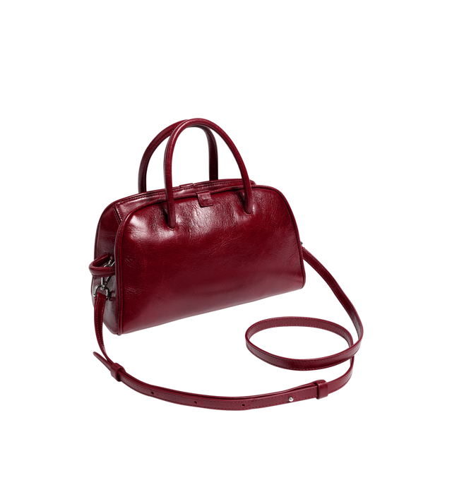 Image 2 of 3 - RED - JACQUEMUS Le Petit Turismo Bag featuring bowling bag in shiny vintage-finished leather, double-sided zipper, tubular handles in matching leather, knotted detail on handle, removable cross-body strap, embossed logo and interior pocket. 10.2 in x 6.3 in x 4.3 in. 100% cow leather. Lining: 100% cotton. Made in Italy.