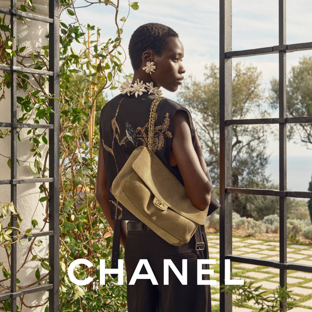 Woman holding a Chanel handbag wearing flower earrings
