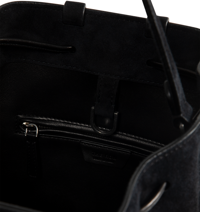 Image 3 of 3 - BLACK - THE ROW Backpack 9 in suede featuring a toggle fastening top, smooth leather trim, gold hardware, 2 adjustable, rivet fastening straps, 1 top handle, logo embossed purse feet at underside, single interior compartment with 1 slit pocket, key ring inside and suede lining. 10.5 W x 10.5 H. 100% calfskin leather. Made in Italy.