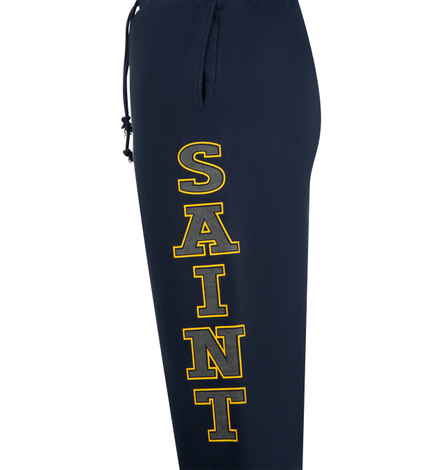 Image 3 of 3 - NAVY - SAINT MICHAEL Saint Sweatpants featuring elastic waist with drawstrings, side pockets, back pocket and graphic print down legs. 100% cotton. Made in Japan.