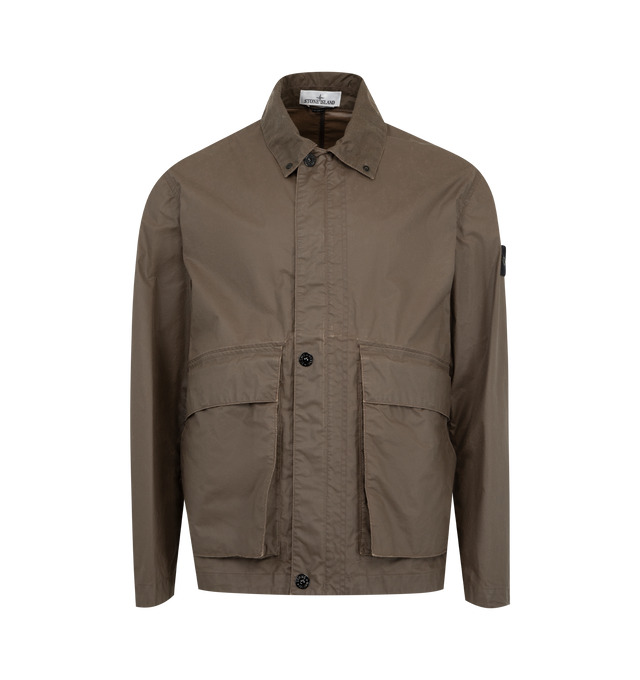 Image 1 of 4 - BROWN - STONE ISLAND Coach Jacket featuring collar with snap to wear standing, top-entry bellows hand pockets with flap and concealed snap, with overlapping angled pockets, eyelets under back armholes, Stone Island badge on left sleeve, adjustable cuffs with snap and two-way zipper fastening under snap placket. 65% polyester, 35% cotton.