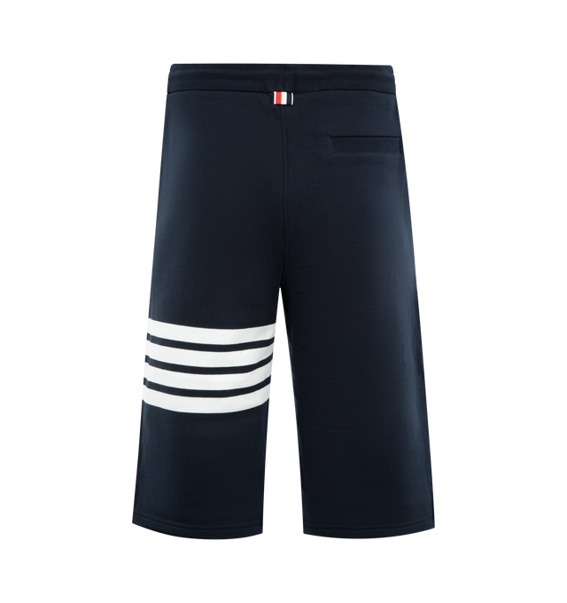 Image 2 of 3 - NAVY - THOM BROWNE Classic Loopback 4-Bar Sweatshorts featuring drawstring waistband with silver tone aglets, engineered 4-bar stripe detail at left thigh, name tag applique above left cuff, slip side pockets, single back welt pocket and signature striped grosgrain loop tab at back waist. 100% cotton. Made in Japan.