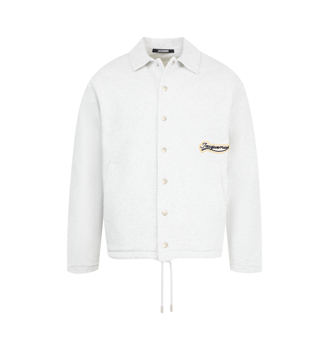 Image 1 of 3 - WHITE - JACQUEMUS Gio Overshirt featuring relaxed fit, brushed cotton fleece, pointed collar, snap button closure, embroidered varsity patch on the front, welt pocket, drawstring hem, embroidered J patch on the back, hip length and fully lined in jersey. 100% cotton. Lining: 100% cotton. Made in Portugal.