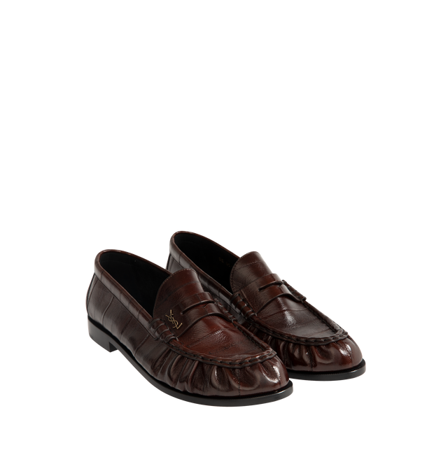 Image 2 of 4 - BROWN - Saint Laurent Mens Penny Loafers are crafted from supple eel skin leather. Feature a hand-stitched moc toe, gold-tone Cassandre hardware, classic penny loafer silhouette, and leather sole. Main Material: Eel Skin Leather; Hardware: Brass; Sole: Leather. Made in Italy.