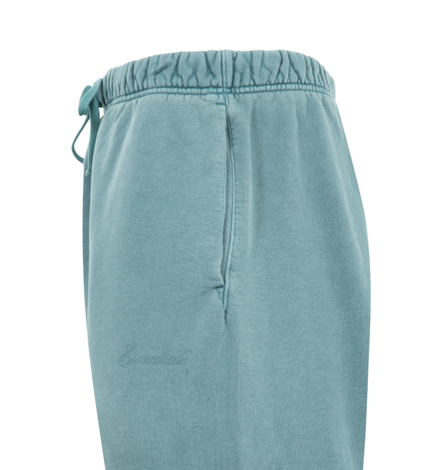 Image 3 of 3 - BLUE - FEAR OF GOD ESSENTIALS Signature Classic Flare Sweatpant featuring 520GSM heavyweight fleece, pigment-dyed, relaxed silhouette, flared leg, an encased elastic waistband with elongated drawcords, side-seam pockets, Essentials signature logo embroidered on the leg and an Essentials signature label at the center front. 100% cotton.