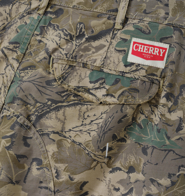 Image 4 of 7 - GREEN - Cherry LA Wide Leg Cargo Pants are crafted from custom camouflage cotton ripstop and feature a wide-leg silhouette with utility-inspired cargo pocket detailing. Designed with hidden snap closures at the pockets, paint splatter accents, and distressed finishes throughout, this statement style combines military influences with Cherry LA's signature lived-in aesthetic. Main Material: Custom Camouflage Cotton Ripstop. Fit: Wide Leg. Pockets: Cargo Pockets with Hidden Snap Closures. Detail