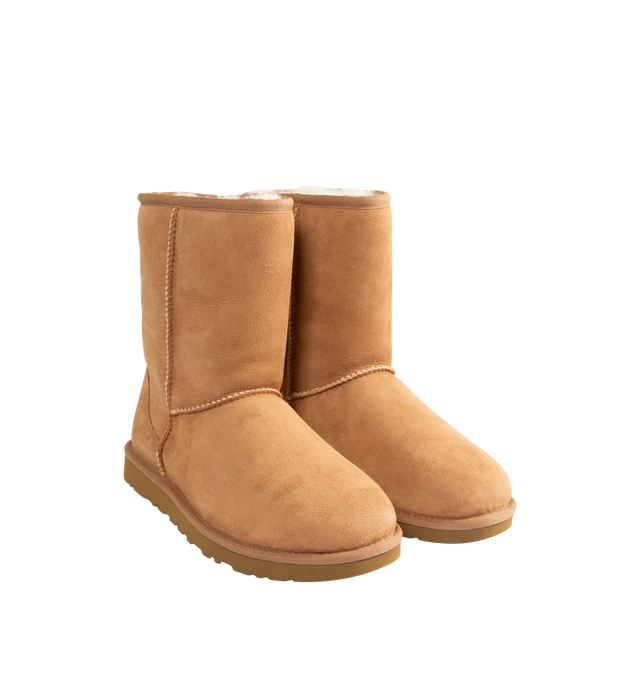 Image 2 of 4 - BROWN - UGG Men's Classic Short Boots are crafted from premium suede and feature the brand's iconic mid-calf silhouette with a soft sheepskin lining and cushioned footbed for signature warmth and comfort. These designer boots combine timeless style with lightweight cushioning and a durable outsole, making them an everyday cold-weather essential. Main Material: Suede. Lining: Sheepskin. Sole: Durable Rubber.