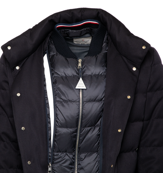 Image 4 of 5 - NAVY - MONCLER Bess Short Down Jacket featuring nylon lger lining, down-filled, pull-out, adjustable rainwear hood with elastic drawstring fastening and snap buttons, contrasting-colored interior piping, ribbed knit collar, inner front bottom with tricolored detailing, zipper and snap button closure, zipped external and internal pockets and leather logo. 100% virgin wool. Lining: 100% polyamide/nylon. Padding: 90% down, 10% feather. 